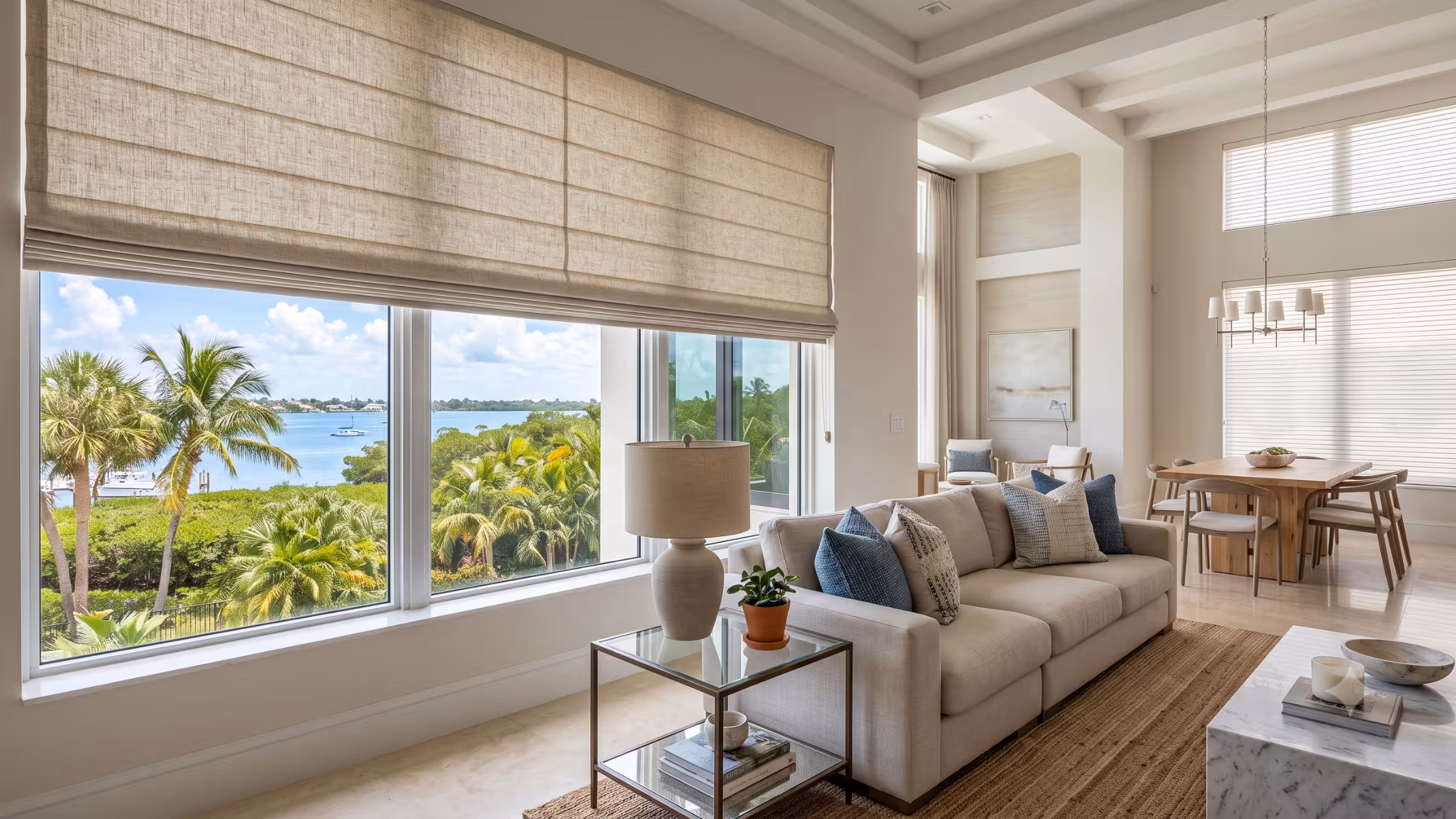 Elegant custom Roman shades with horizontal folds in a light-filled South Florida living room