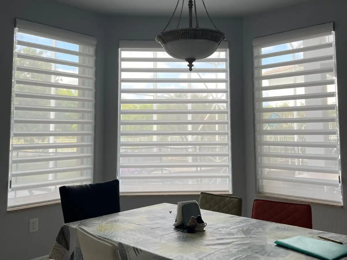 White faux wood blinds on large windows in a Broward County home